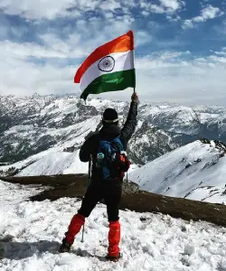 man with indian flag at kedarkantha peak